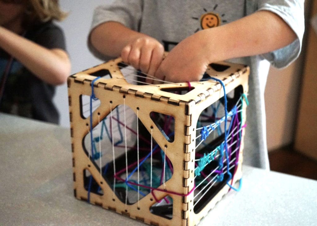 a child working on a weaving project