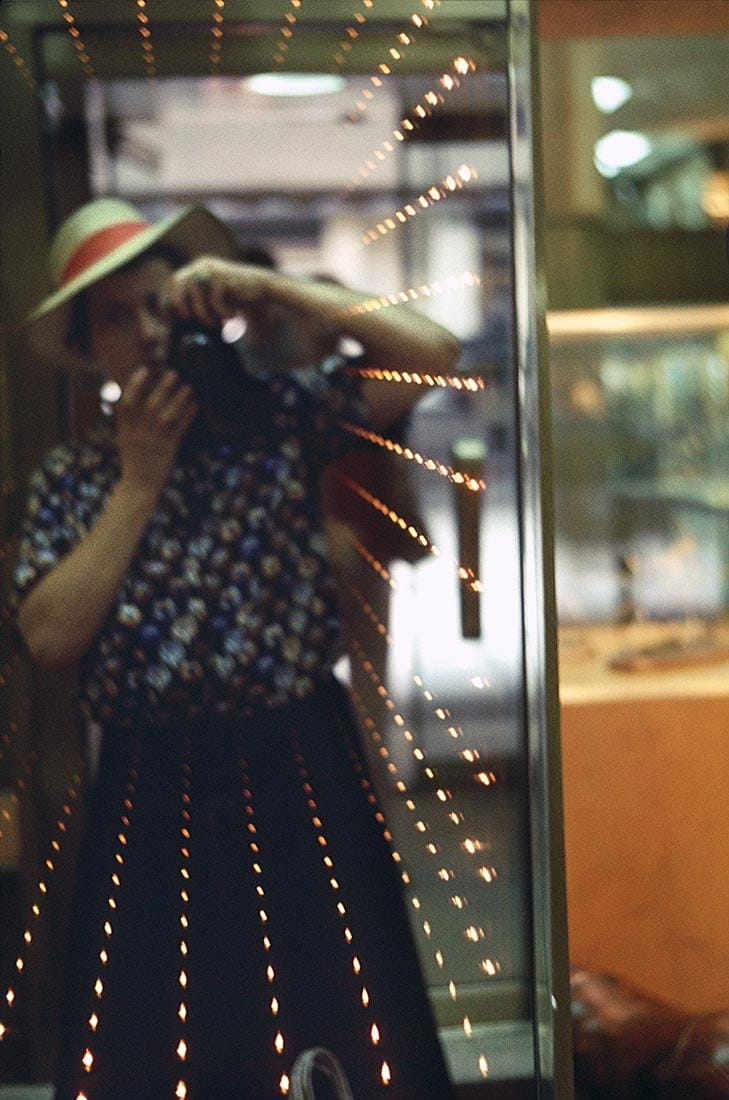 A reflection of a woman taking a photograph of herself