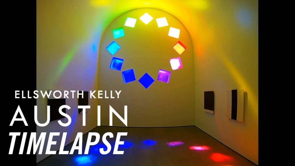 Interior view of Ellsworth Kelly's Austin facing the eastern wall. Twelve rainbow stained glass squares are arranged in a circular pattern described as tumbling rocks. Their shadows cast a colorful circular glow on the floor.