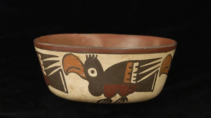 Ceramic bowl with birds painted in profile view around the sides. The inside is solid brown.