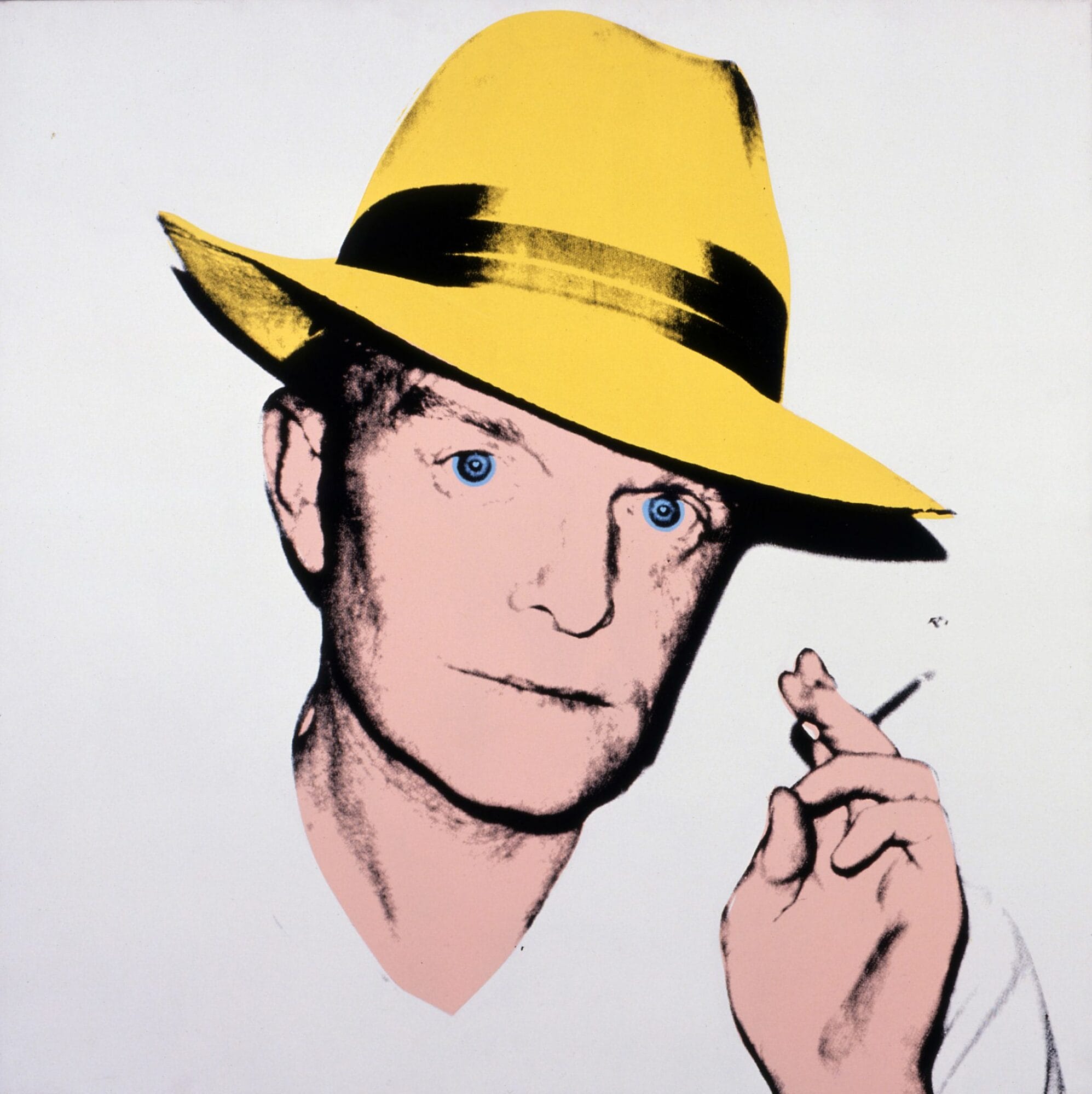 Portrait of Truman Capote, depicted from the shoulders up. He looks at the viewer with a neutral expression, holding up a cigarette in one hand. He is wearing a yellow fedora.