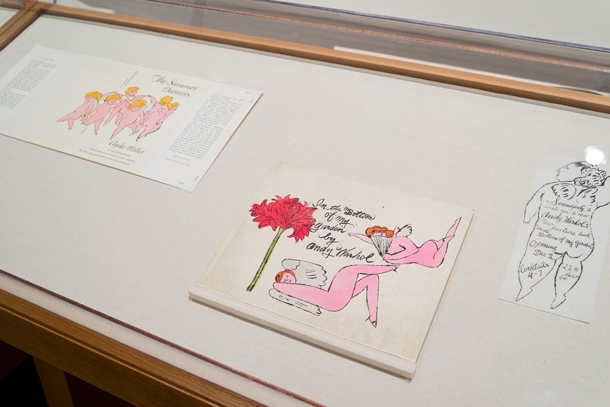 Three illustrations of angels in a display case.