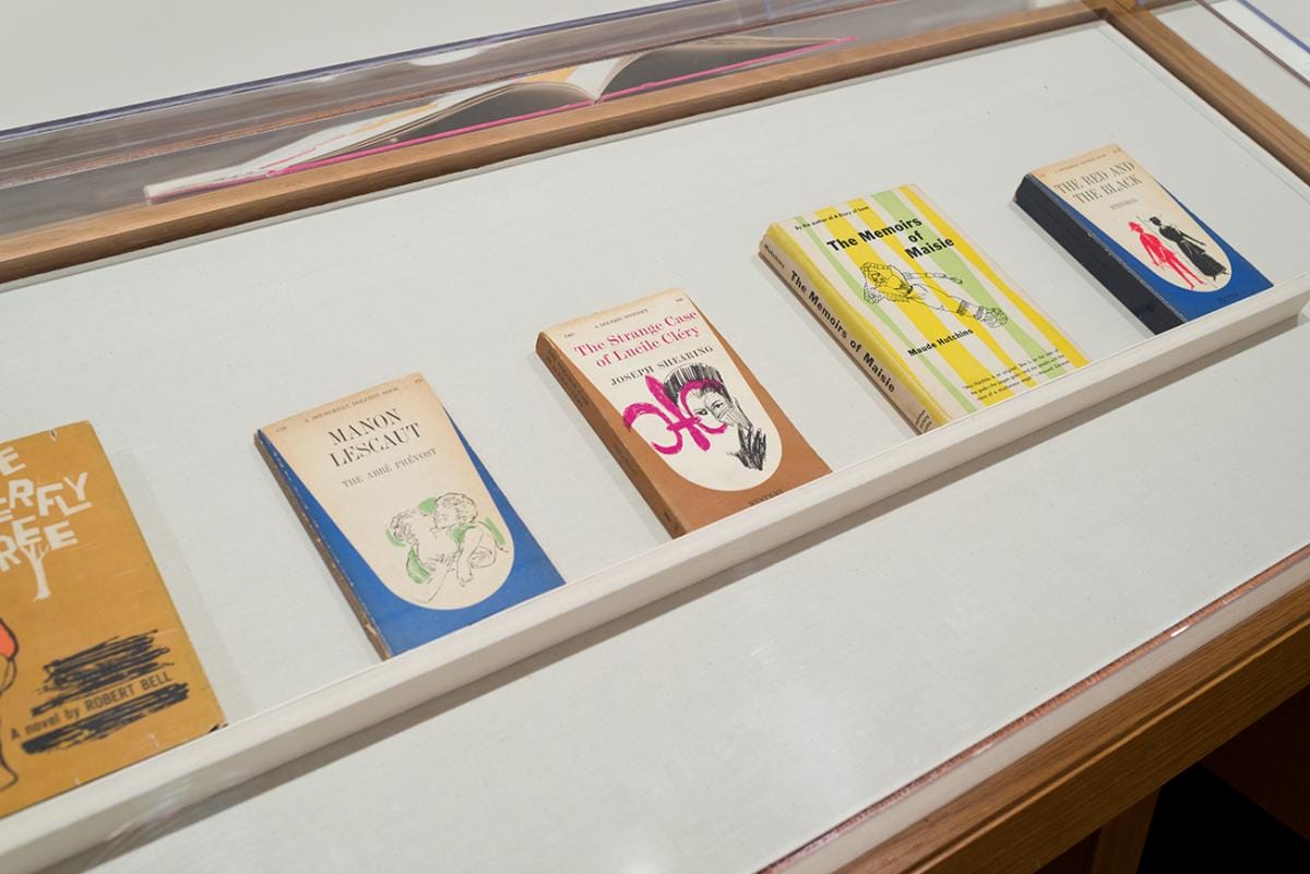 Printed books featuring brightly colored illustrations on their covers in a display case.