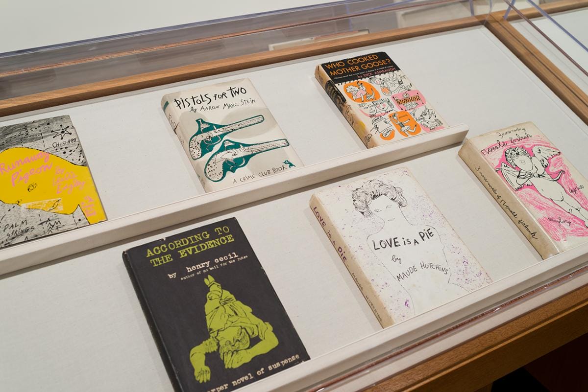 Printed books featuring brightly colored illustrations on their covers in a display case.