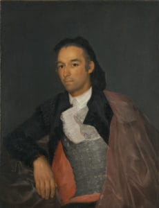 Painted portrait of a matador. He looks at the viewer with a neutral expression. His right arm is bent, resting on a fabric prop, and his left shoulder is draped with a dull red cape.