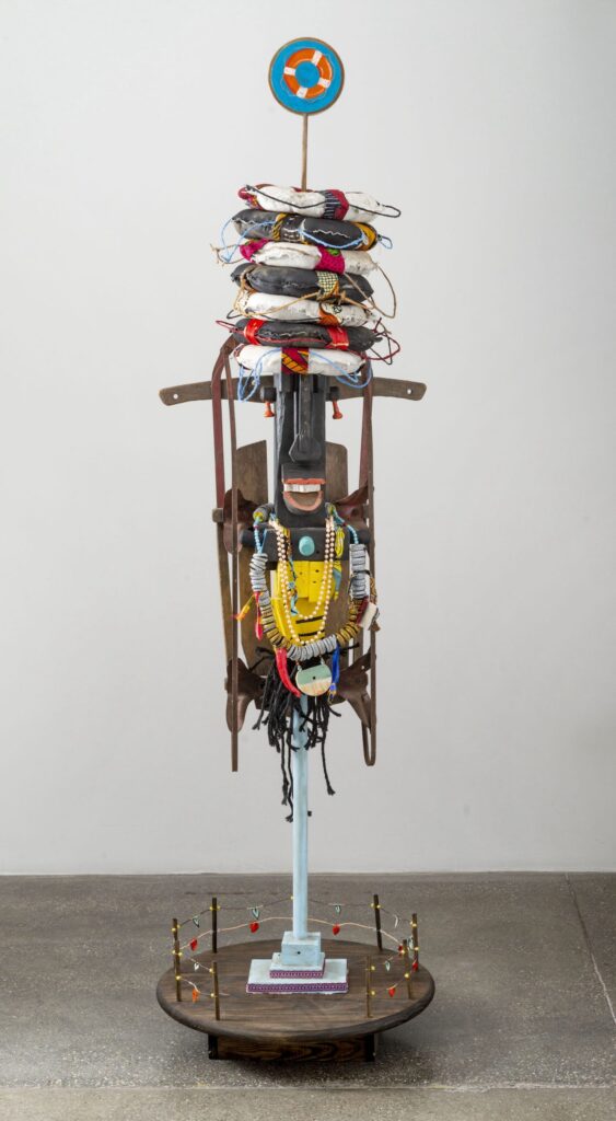 Nyugen E. Smith, "Le Virgin of Seven Buoys," 2022, Assemblage (Found wood, acrylic, yarn beads, beer caps, cork, wire, fabric, diaspora soil, antique sled, plastic, metal, twine, oil pastel, lace, canvas, and gesso), 82 x 23 x 23 in., Courtesy of the artist (Photo: Ed Fausty)